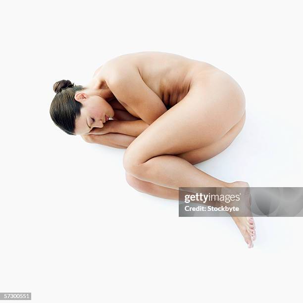 elevated view of a nude young woman sleeping on the floor - hugging knees bildbanksfoton och bilder