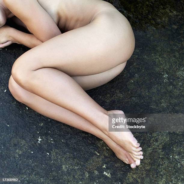 close-up of a nude young woman's legs - position du foetus photos et images de collection