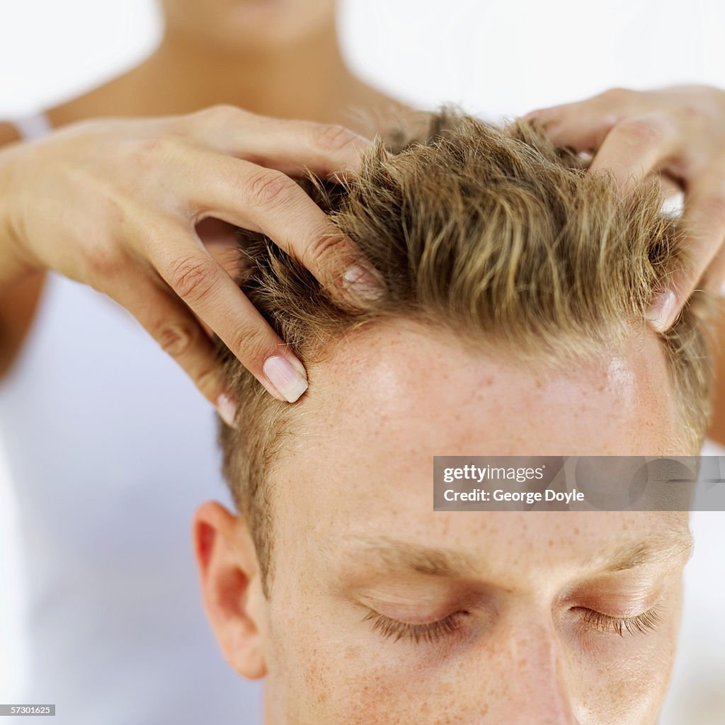 Young man getting a head massage from a woman