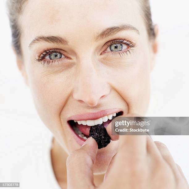 close-up of a young woman eating a prune - dörrpflaume stock-fotos und bilder