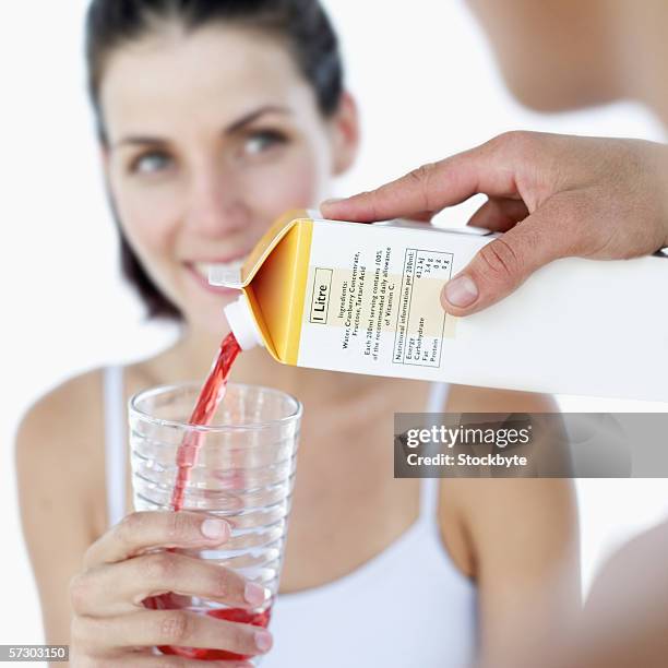 close-up of a young man's hand pouring juice for a young woman - juice box stock pictures, royalty-free photos & images