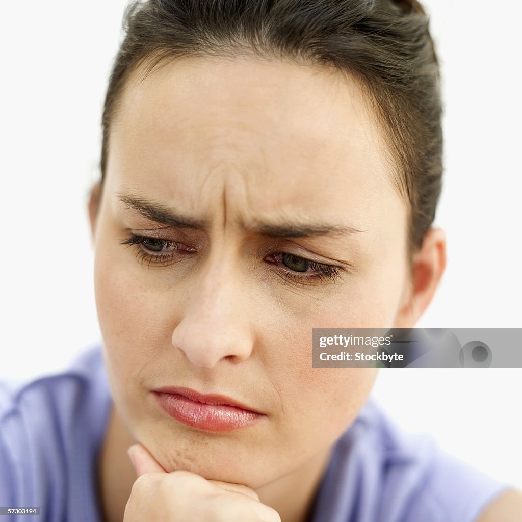 Close-up of a young woman resting chin on hand