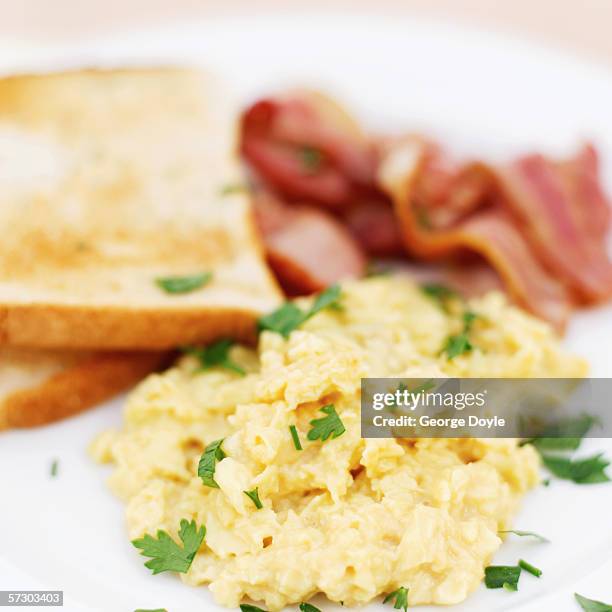 close-up of scrambled eggs served with toast and bacon (blurred) - ovo mexido imagens e fotografias de stock