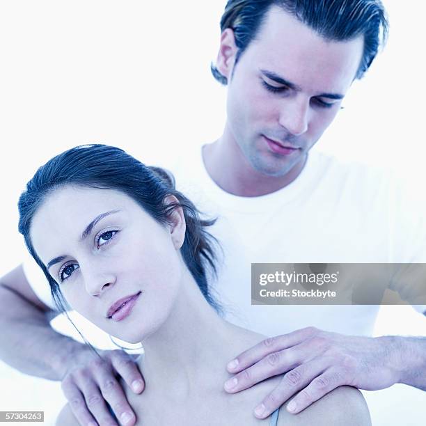 young man massaging a young woman's back - 中年人情侶 個照片及圖片檔