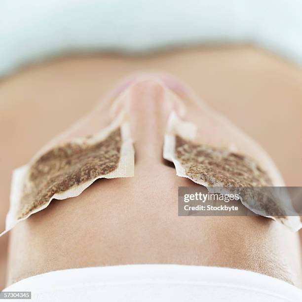 close-up of a woman with teabags on eyes - tea bags stock pictures, royalty-free photos & images