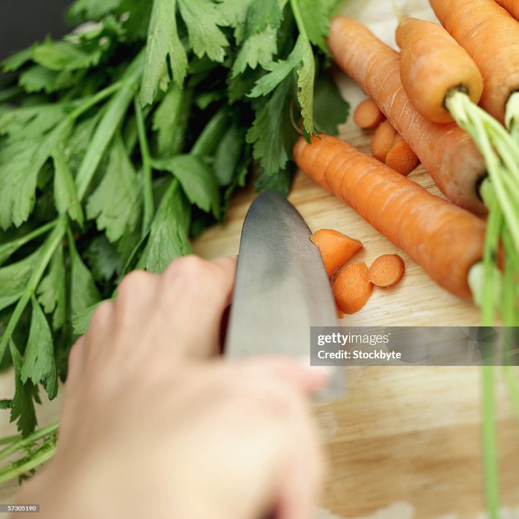 Woman chopping carrots with a knife