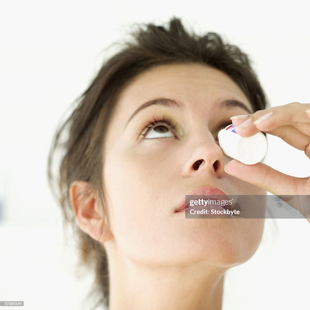 Close-up of a young woman putting eye drops in her eyes