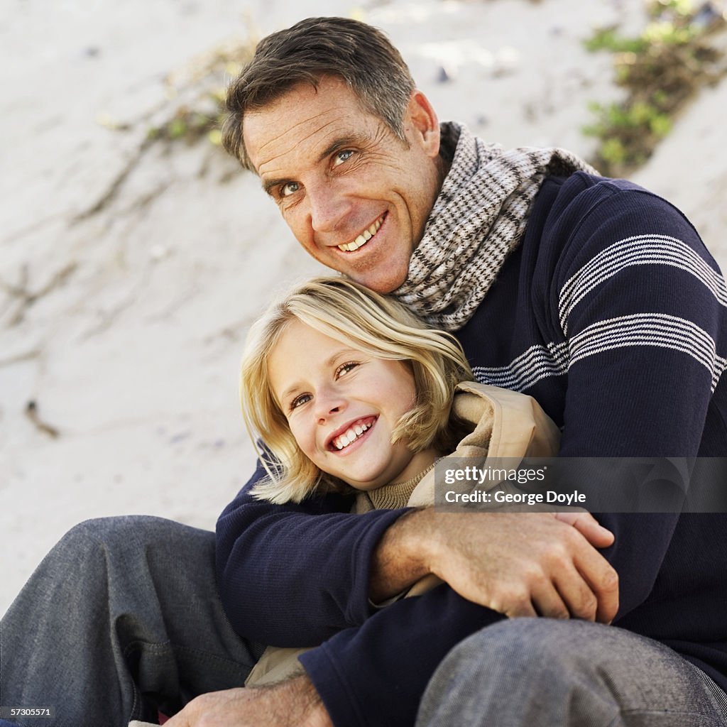 Portrait of father holding his daughter looking up