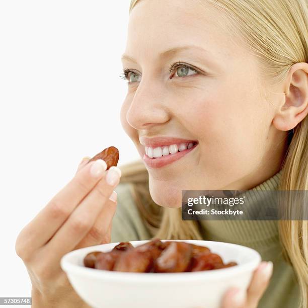 young woman eating a prune - dried plum stock pictures, royalty-free photos & images