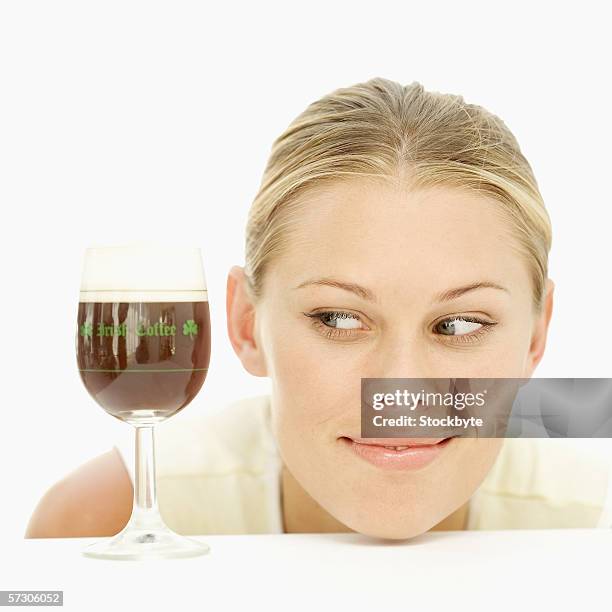 young woman looking at a glass of irish coffee - coffee drink on white stock pictures, royalty-free photos & images