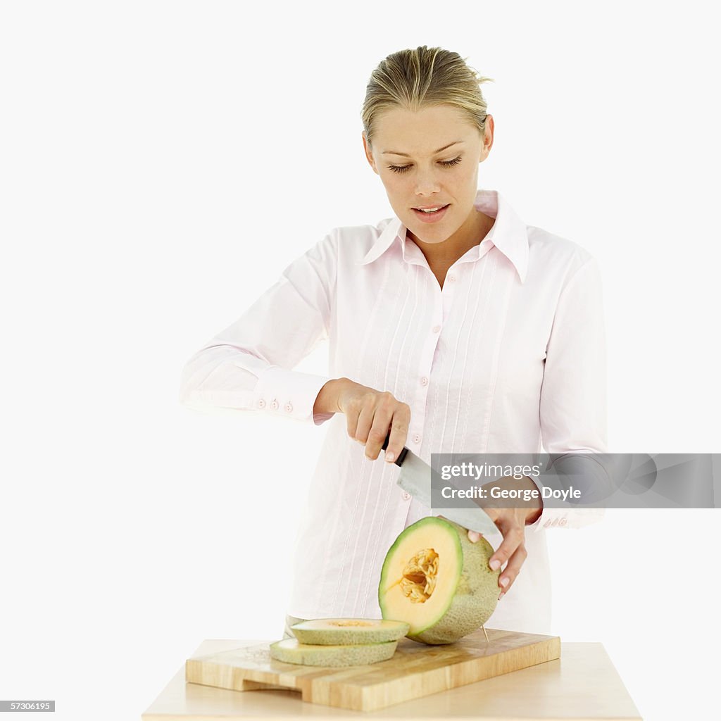 Young woman slicing a cantaloupe