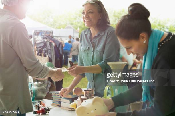 hispanic women shopping at flea market - flea market stockfoto's en -beelden