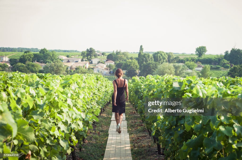 Caucasian woman walking on wooden walkway in vineyard