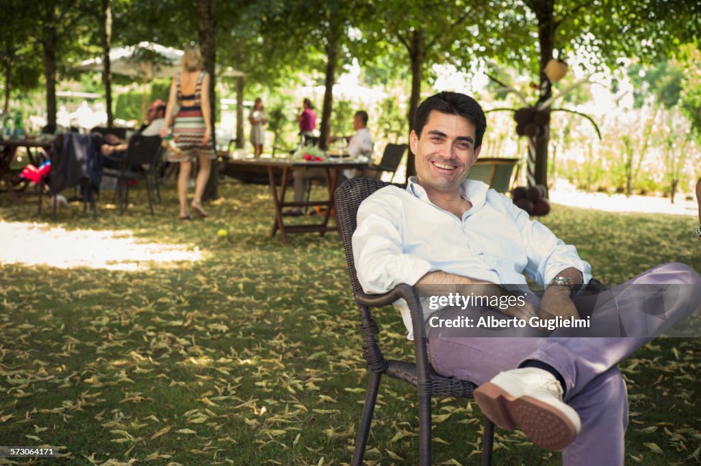 Caucasian man sitting in chair in backyard