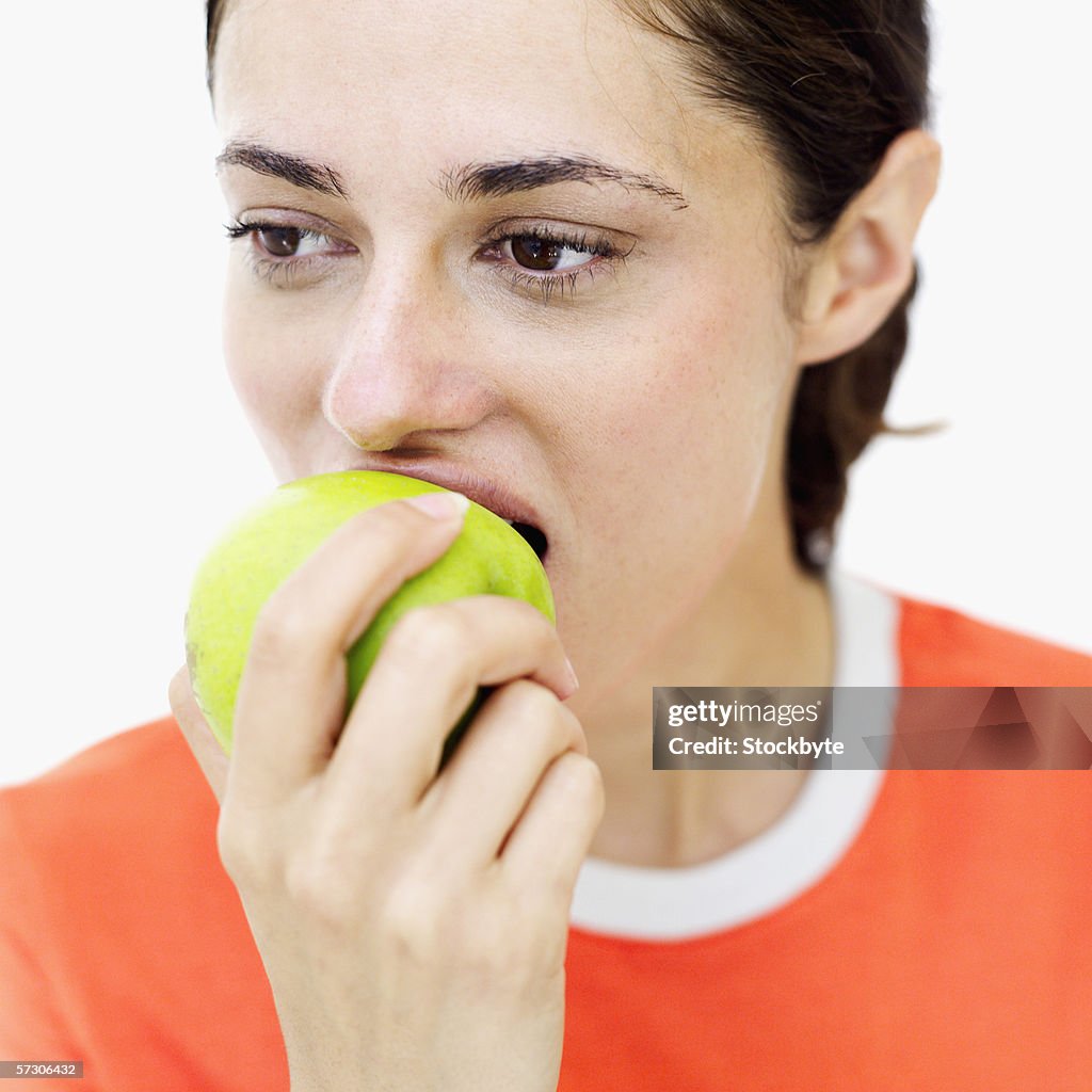 Close-up of a young woman biting into an apple
