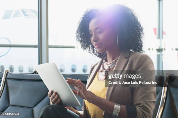 businesswoman using digital tablet in airport waiting area - close up gate stockfoto's en -beelden