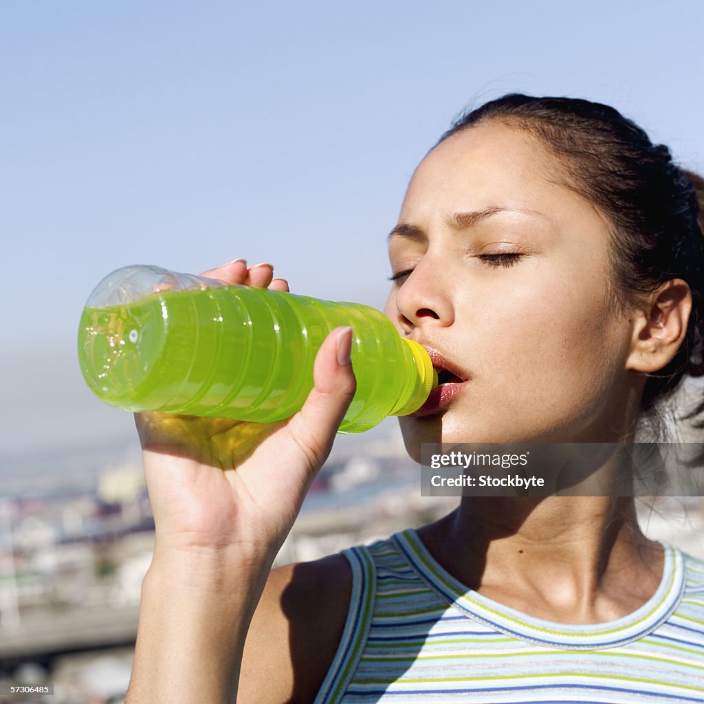 Close-up of a young woman drinking juice from a bottle