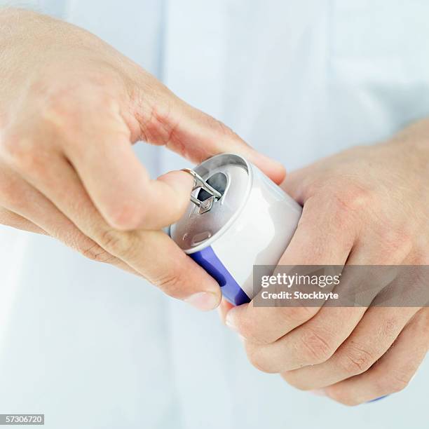 close-up of a man's hands opening a soft drink can - energydrink stock-fotos und bilder