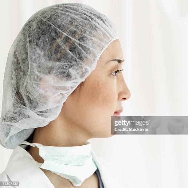 side profile of a young female surgeon wearing scrubs - surgical mask profile stock pictures, royalty-free photos & images