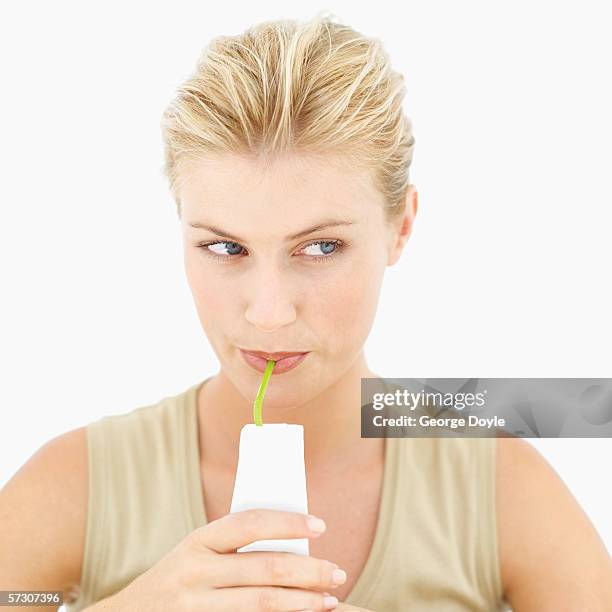 close-up of a young woman drinking juice with a straw - juice box stock pictures, royalty-free photos & images