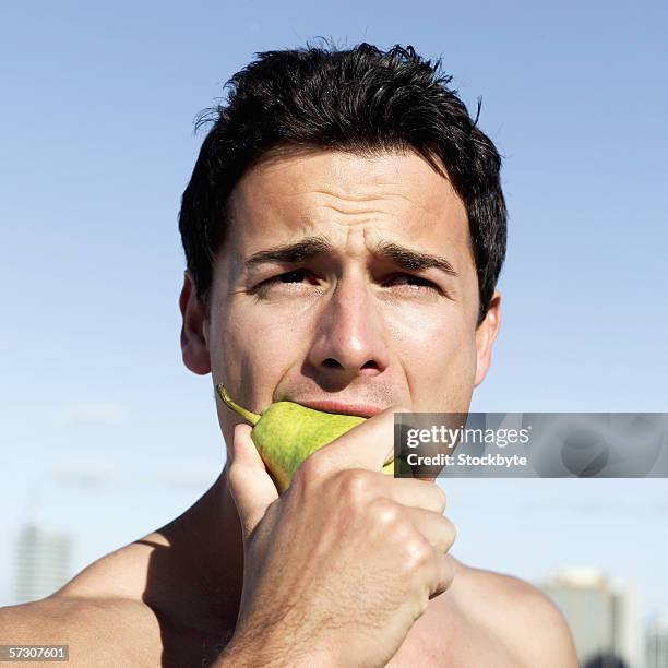 close-up of a young man eating a pear - pear stock pictures, royalty-free photos & images