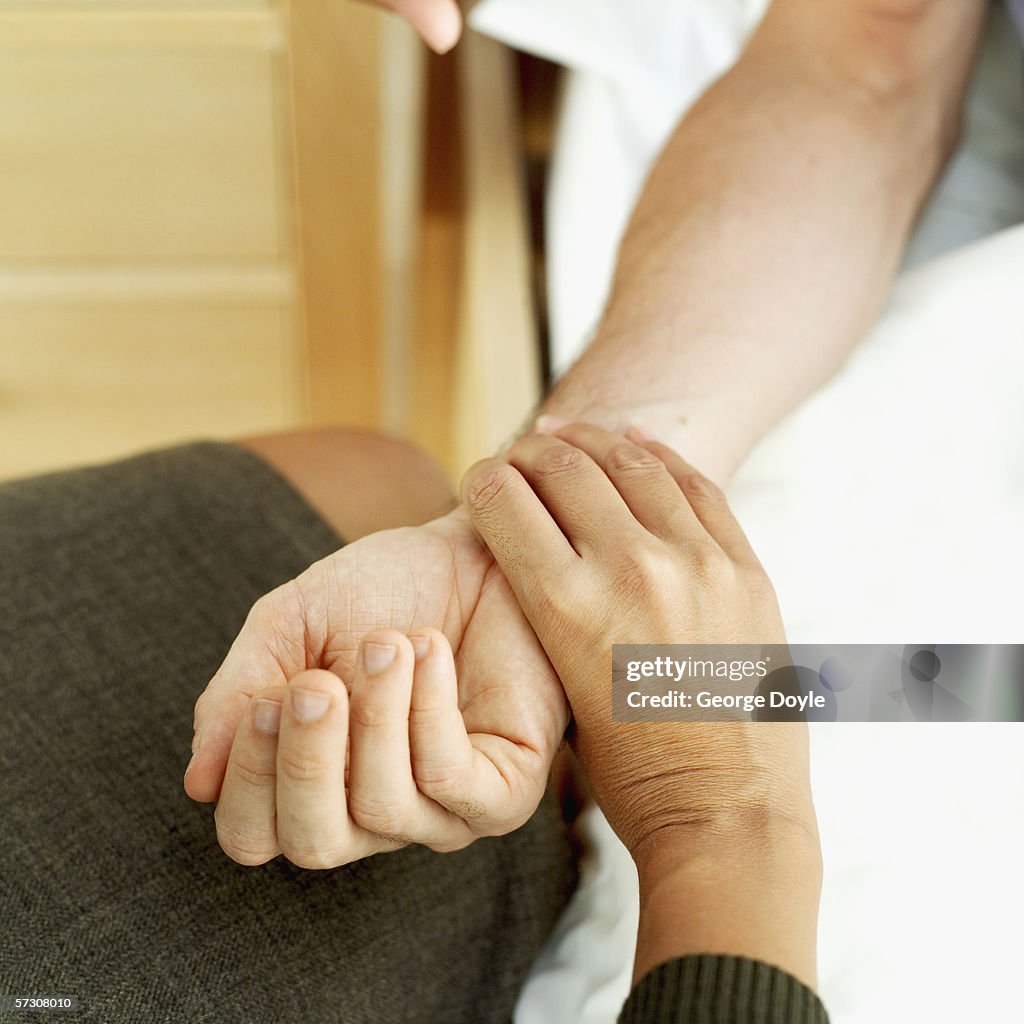 Female doctor checking a person's pulse