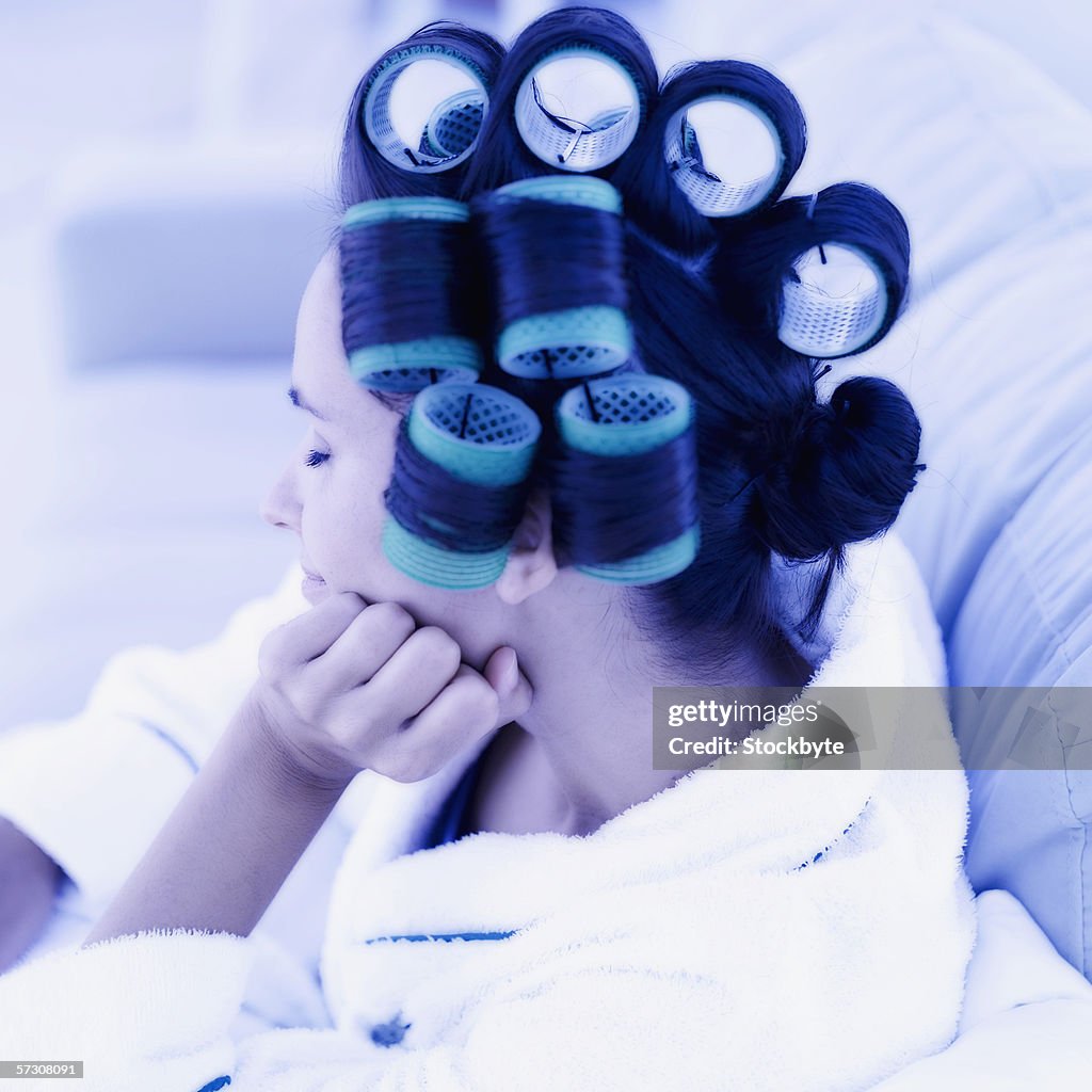 Young woman with curlers in hair