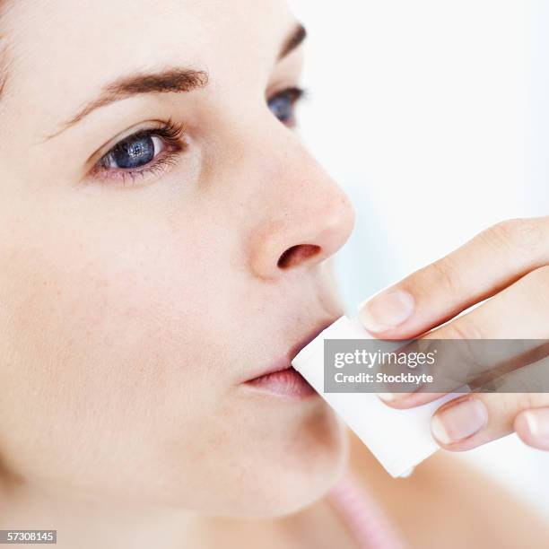 close-up of a young woman sipping from a mouthwash cup - mundspülung stock-fotos und bilder