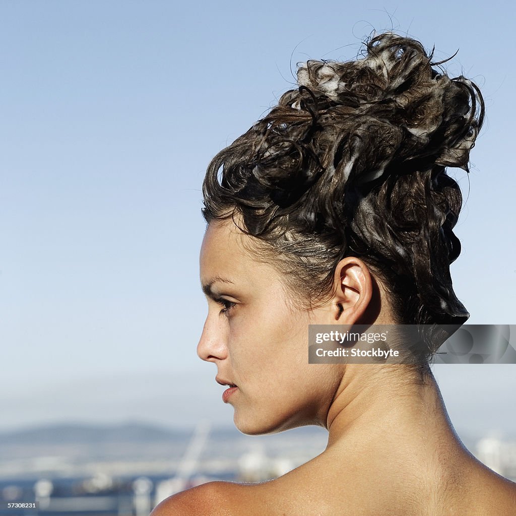 Rear view of young woman with shampoo in hair