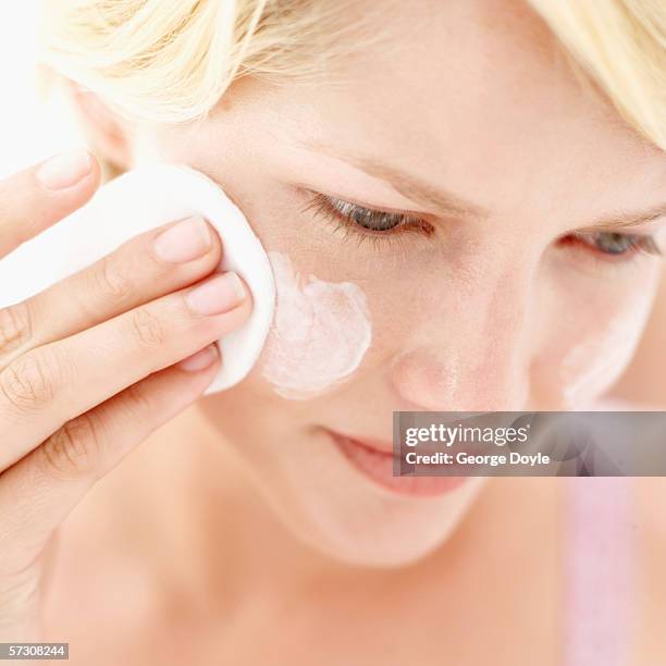 young woman applying cream with applicator - woman applying cotton ball stock pictures, royalty-free photos & images