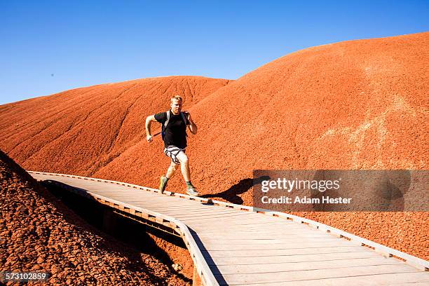 caucasian man running on walkway in desert hills - john day fossil beds national park 個照片及圖片檔
