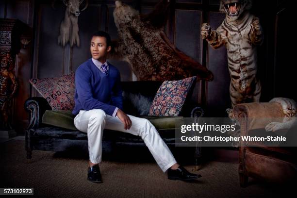 man sitting in parlor with stuffed animals - svarta byxor bildbanksfoton och bilder