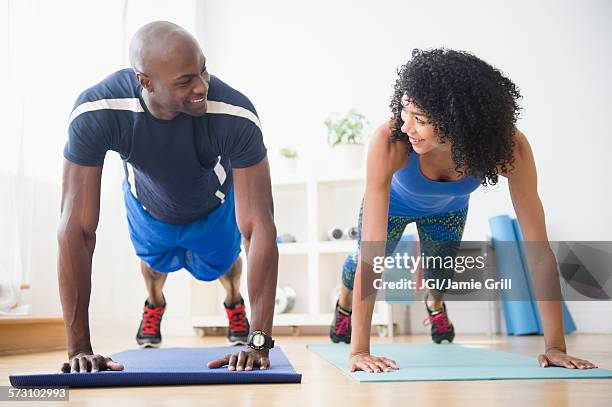 couple doing push-ups in gym - flirting gym stock pictures, royalty-free photos & images