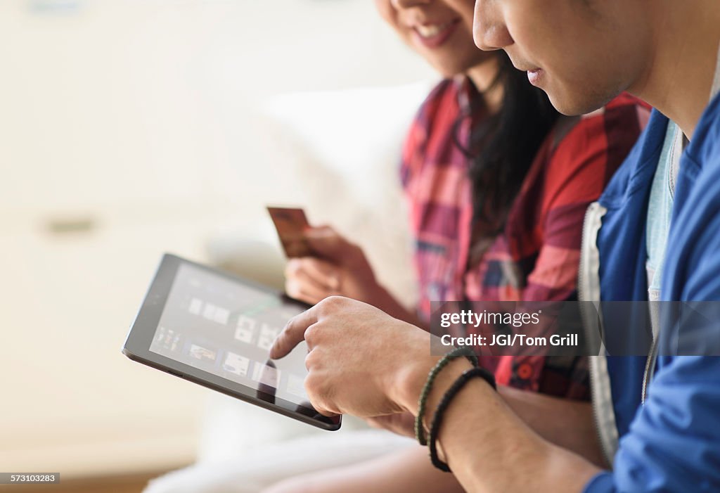 Close up of couple shopping online on digital tablet