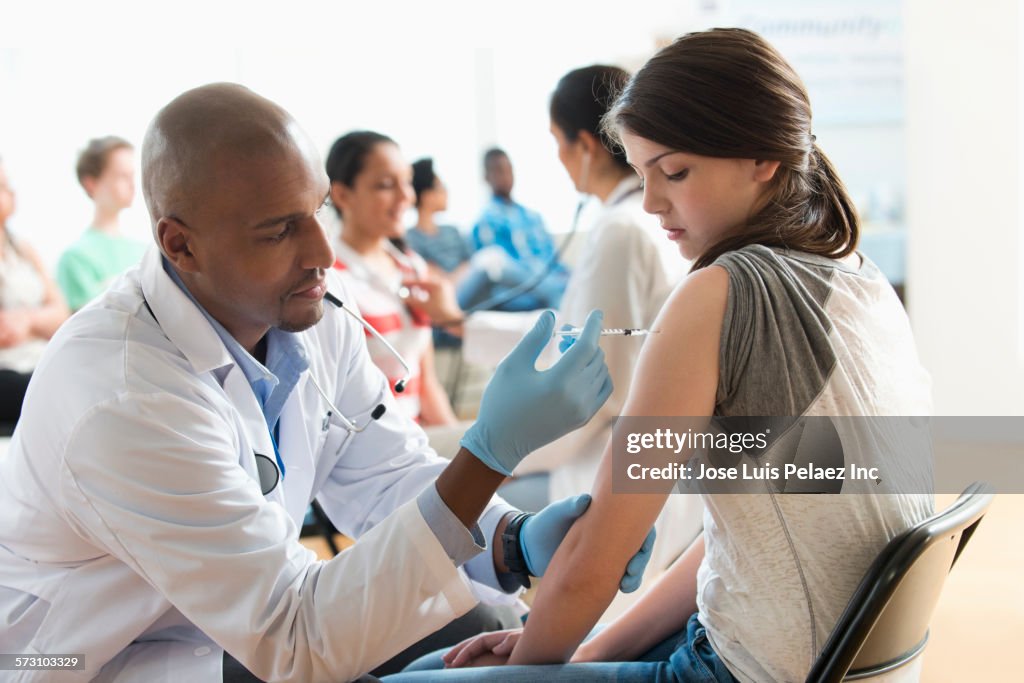 Doctor giving patient injection in volunteer clinic