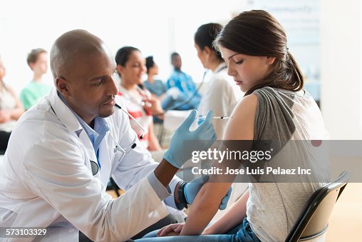 Doctor giving patient injection in volunteer clinic Doctor giving patient injection in volunteer clinic
