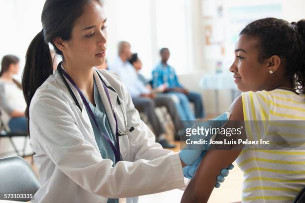 doctor disinfecting arm of patient in volunteer clinic - test preparation stock pictures, royalty-free photos & images