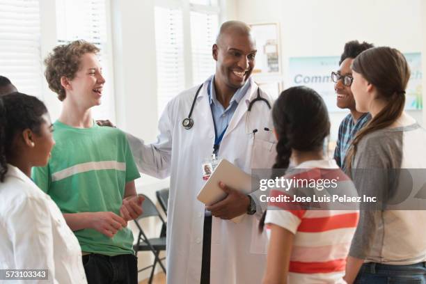 doctor and patients talking in volunteer clinic - patient profile stock pictures, royalty-free photos & images