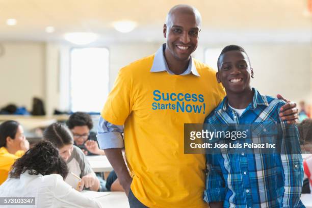 volunteer mentor smiling with student - male volunteer stockfoto's en -beelden