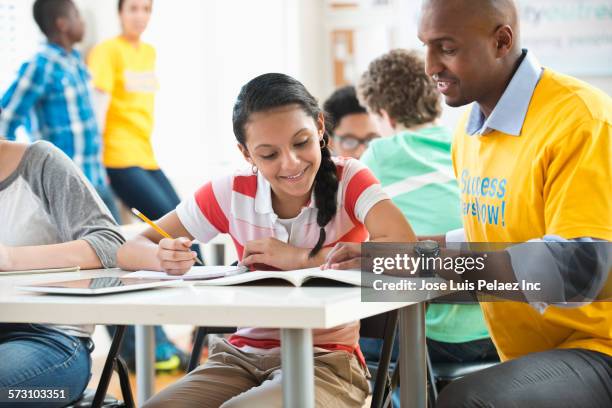 volunteer mentor helping student with homework - 13 pencils stockfoto's en -beelden