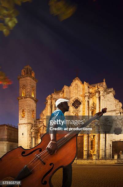hispanic musician carrying upright bass near church, havana, cuba - double bass stock pictures, royalty-free photos & images