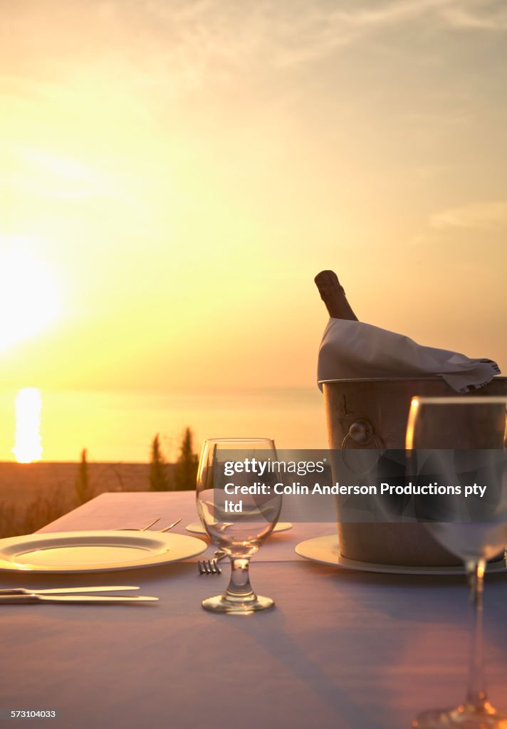 Champagne bucket at empty table at sunset