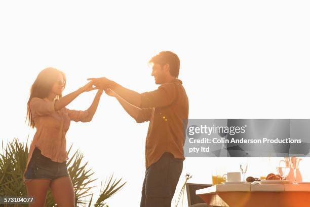 hispanic couple dancing at table outdoors - lens flare young people dancing on beach stock pictures, royalty-free photos & images