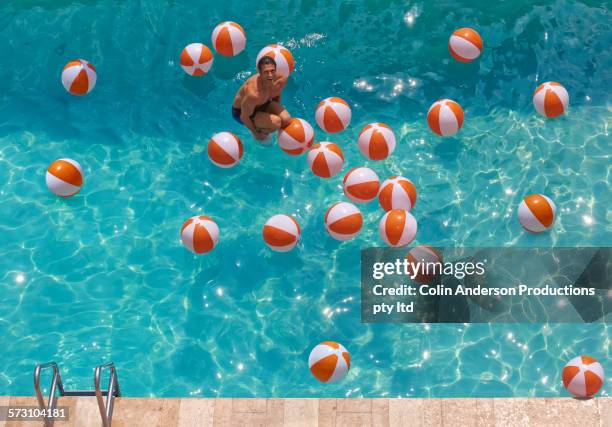 overhead view of hispanic man jumping in swimming pool - cannon ball pool stock pictures, royalty-free photos & images