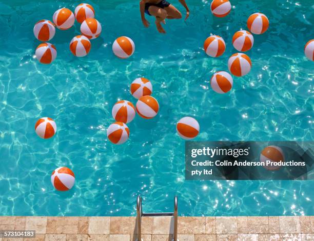 overhead view of hispanic man jumping in swimming pool - cannon ball pool stock pictures, royalty-free photos & images