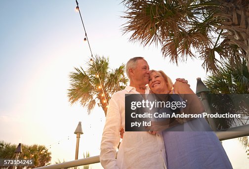 Low angle view of older Caucasian couple hugging outdoors Low angle view of older Caucasian couple hugging outdoors
