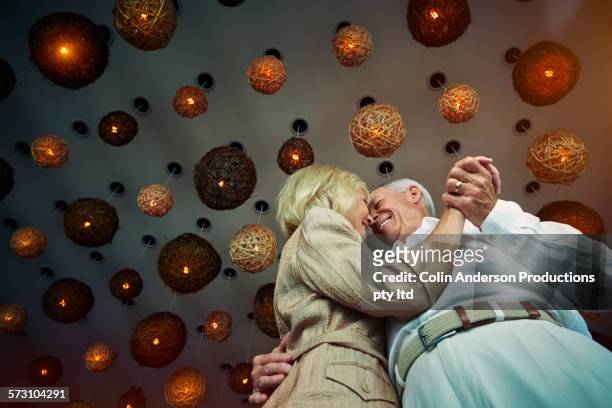 low angle view of older caucasian couple dancing - old couple restaurant stock-fotos und bilder