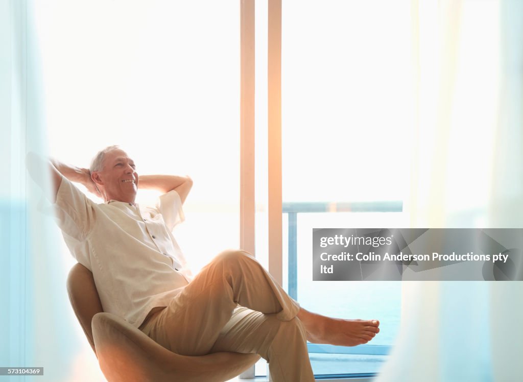 Older Caucasian man sitting at window