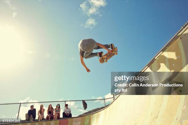 man performing trick on skateboard at skate park - skateboard park stock pictures, royalty-free photos & images