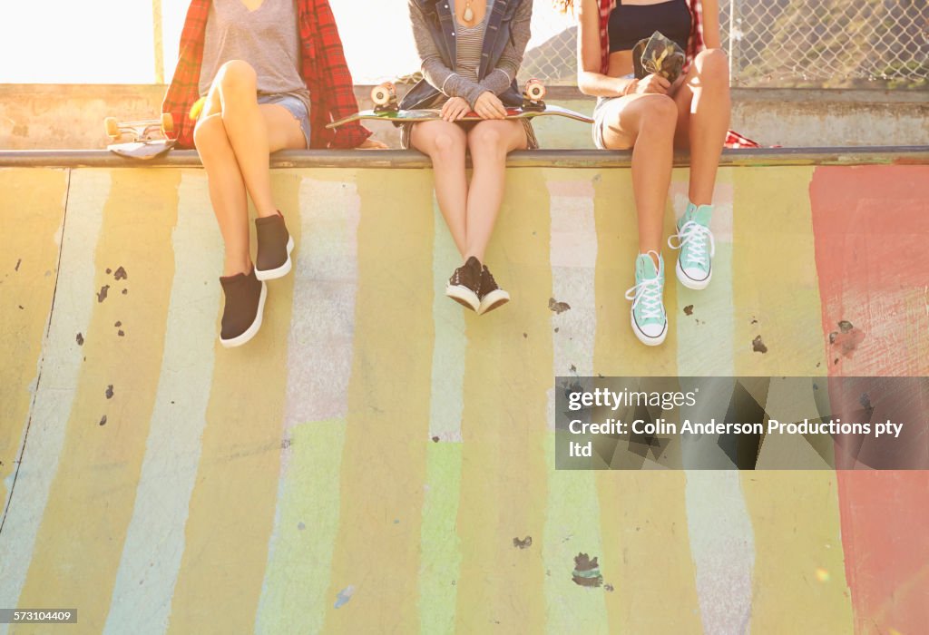 Friends sitting on ramp in skate park